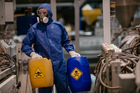 身着防护服的工厂工人正在搬运有害化学品